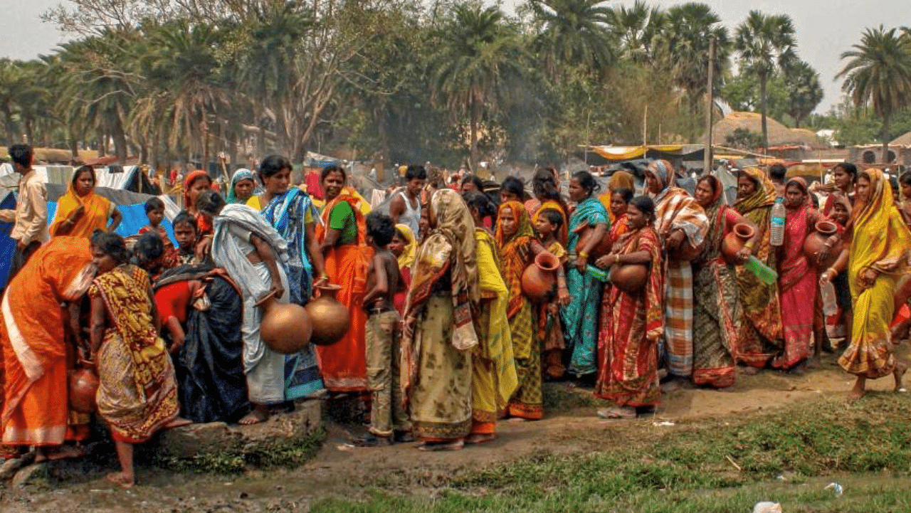 Village women lined up to collect drinking water from a well during the summer season, on the outskirts of Suri in Birbhum district of West Bengal. Credit: PTI Photo