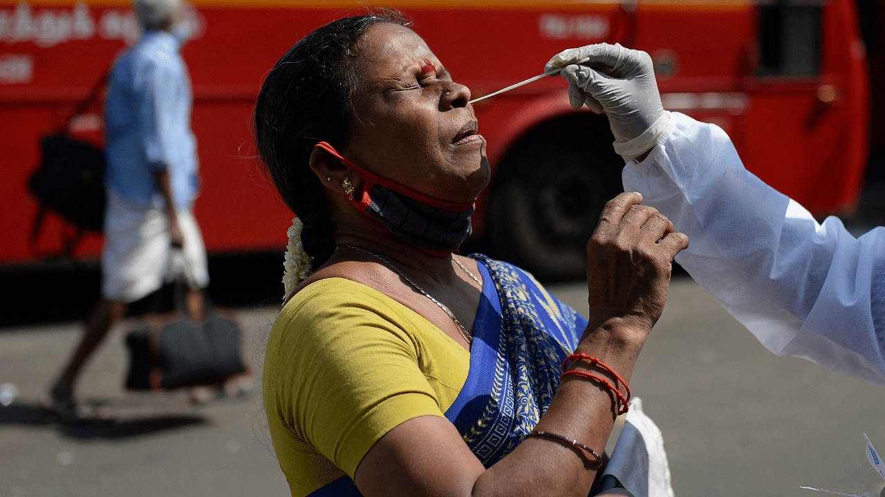 A health worker takes a swab sample from a woman for a RT-PCR Covid-19 coronavirus test. Credit: AFP Photo