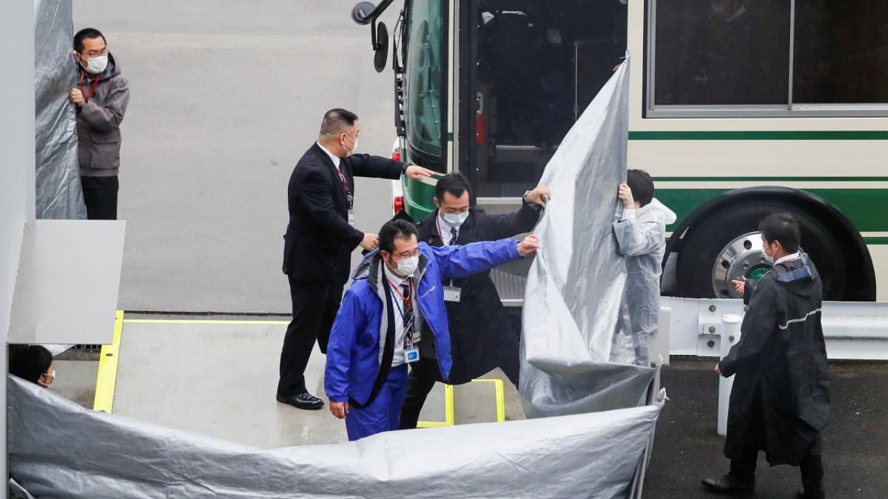 Japanese officers get prepared to escort US citizens Michael Taylor and his son Peter Taylor, suspected of helping former Nissan Motor Chairman Carlos Ghosn to escape to Lebanon, upon their arrival at Narita airport, following their extradition to Japanese Prosecutors, in Chiba. Credit: Reuters.