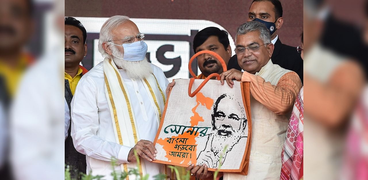 Narendra Modi being presented a jute bag with his portrait on it by Dilip Ghosh. Credit: PTI Photo