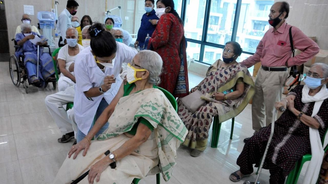 A medic administers first dose of Covid-19 vaccine to an elderly woman as other senior citizens wait, at Mayor's Health Clinic in Kolkata. Credit: PTI.