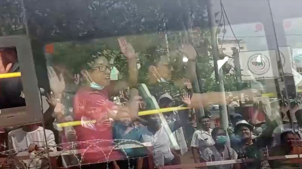 <div class="paragraphs"><p>Onlookers are reflected off the windows as anti-coup demonstrators gesture from the bus after being released from Insein prison in Yangon, Myanmar. </p></div>