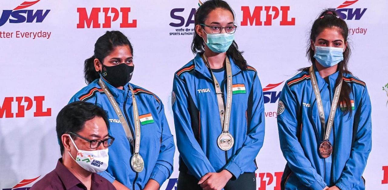 India's Sports Minister Kiren Rijiju poses along with silver medalist India's Rahi Sarnobat, gold medalist Chinki Yadav, bronze medalist Manu Bhaker during a medal ceremony for the women's 25m pistol final of the ISSF World Cup 2021 at Karni Singh Shooting Range, in New Delhi on March 24, 2021. Credit: AFP Photo