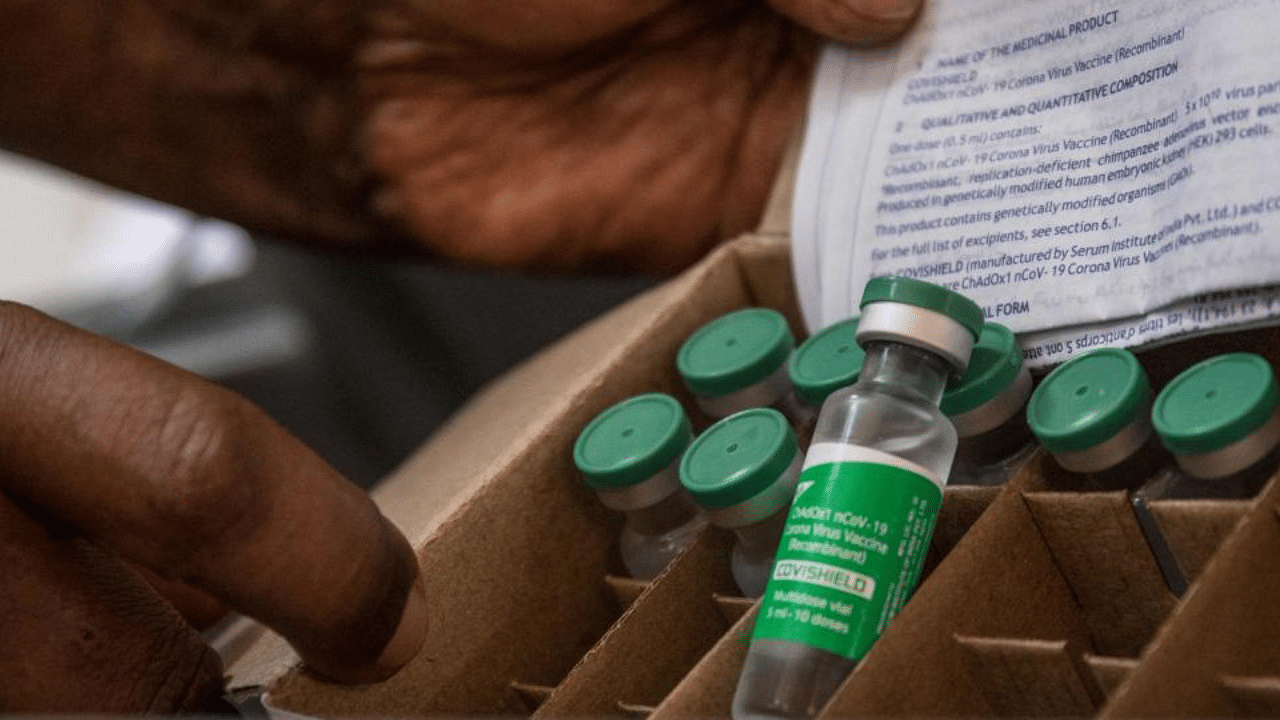 A staff member of Uganda's ministry of health holds a box of Oxford AstraZeneca Covid-19 vaccines at Mulago referral hospital in Kampala, on the first day of a vaccination campaign on March 10, 2021. Credit: AFP Photo