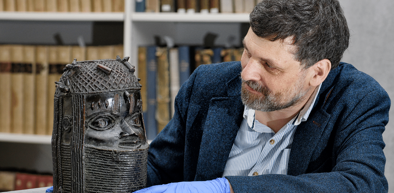 Neil Curtis, Head of Museums and Special collections is seen with one of the Benin bronze depicting the Oba of Benin at The Sir Duncan Rice Library in Aberdeen. Credit: Reuters Photo