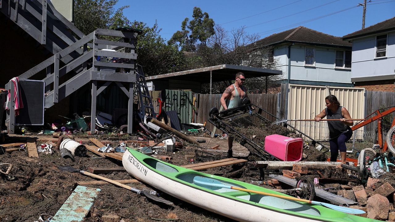 Local residents clean up debris in the aftermath of flooding in Australia. Credit: Reuters