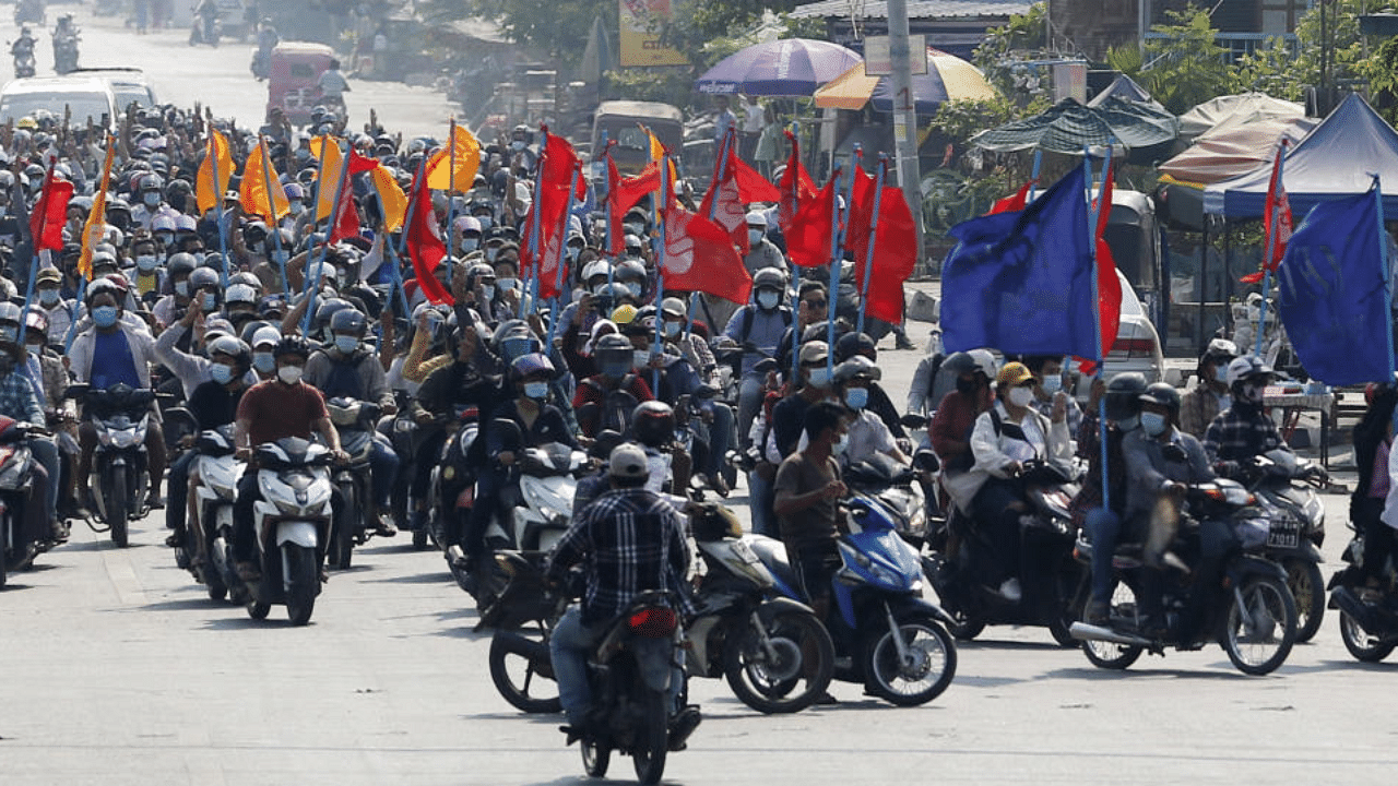 : Protesters carry flags as they drive their motorcycles during an anti-coup protest in Mandalay, Myanmar on Thursday March 25, 2021. Credit: AP Photo