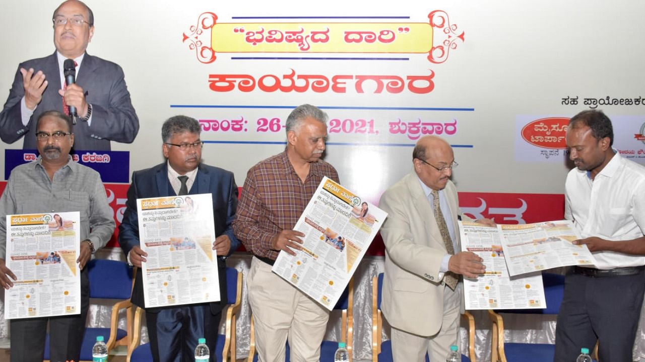 Academician Gururaja Karajagi and UoM Registrar R Shivappa release Sparda Vani, a supplement of Prajavani, for aspirants of competitive exams, in Mysuru. Credit: DH photo.