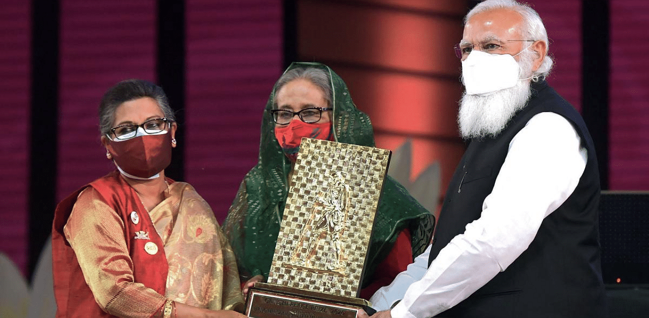 Prime Minister Narendra Modi hands over the Gandhi Peace Prize given posthumously to Bangladesh's founder Sheikh Mujibur Rahman to his daughters Bangladesh's Prime Minister Sheikh Hasina (C) and Sheikh Rehana, in Dhaka. Credit: AFP photo. 