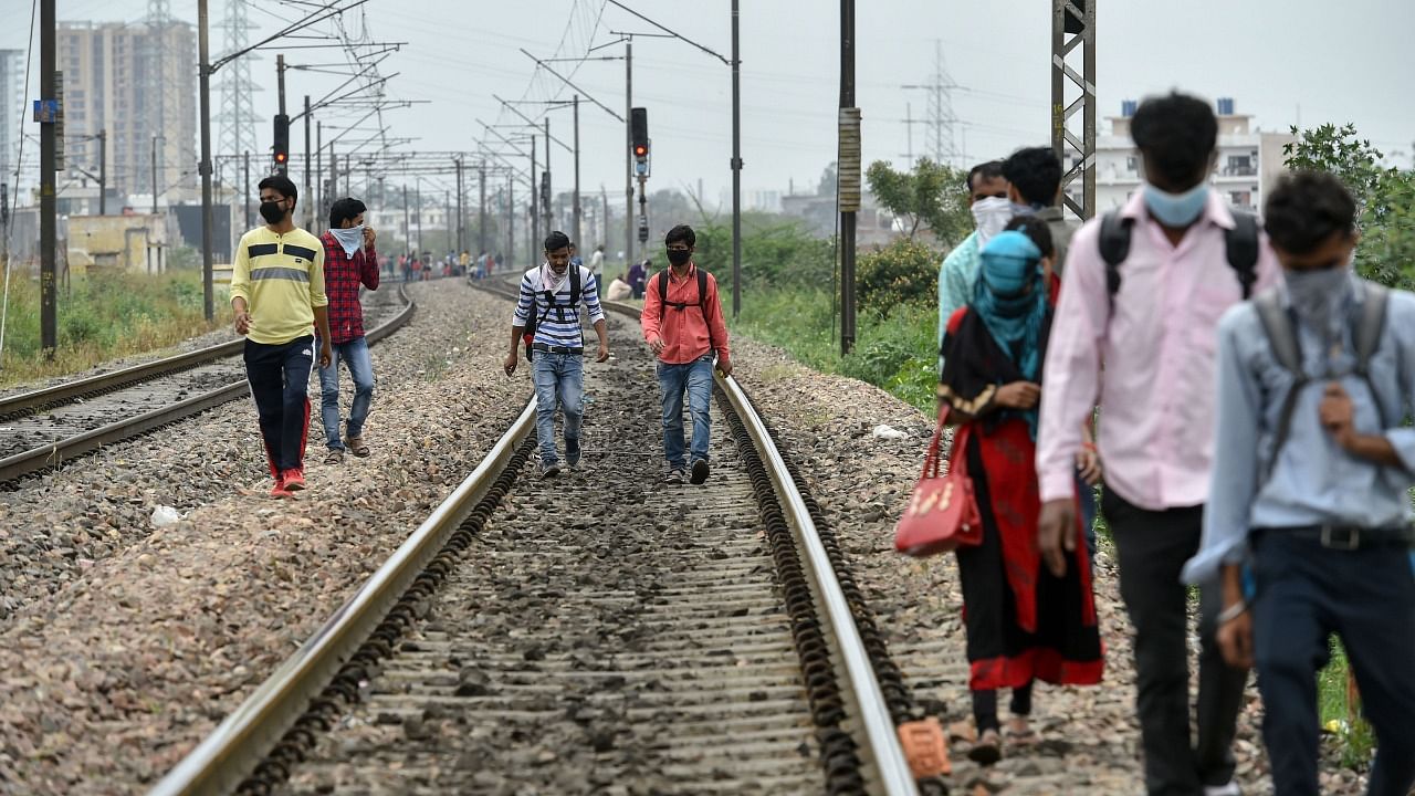 Migrant workers walk on railway tracks after they couldn't find any transport to return to their native places, during a 21-day nationwide lockdown. Credit: PTI File Photo