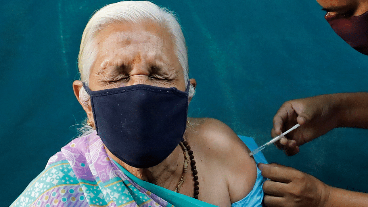 A woman reacts as she receives a dose of COVISHIELD, a coronavirus disease (Covid-19) vaccine, in Ahmedabad. Credit: PTI Photo