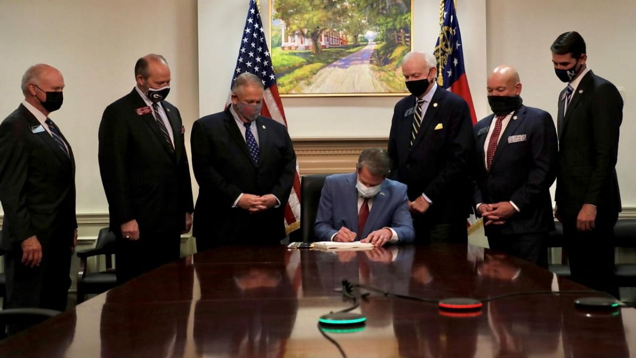 Republican Governor Brian Kemp signs the law S.B. 202, a restrictive voting law that activists have said aimed to curtail the influence of Black voters who were instrumental in state elections that helped Democrats win the White House. Credit: Governor Brian Kemp's Twitter feed/Handout/Reuters.