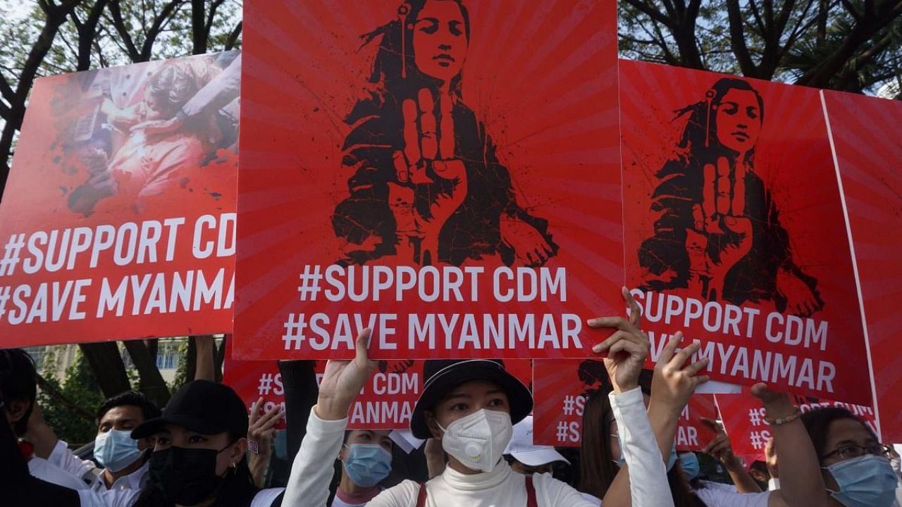 In this file photo taken on February 15, 2021 protesters hold up signs supporting the Civil Disobedience Movement (CDM) during a demonstration against the military coup in Yangon. Credit: AFP.