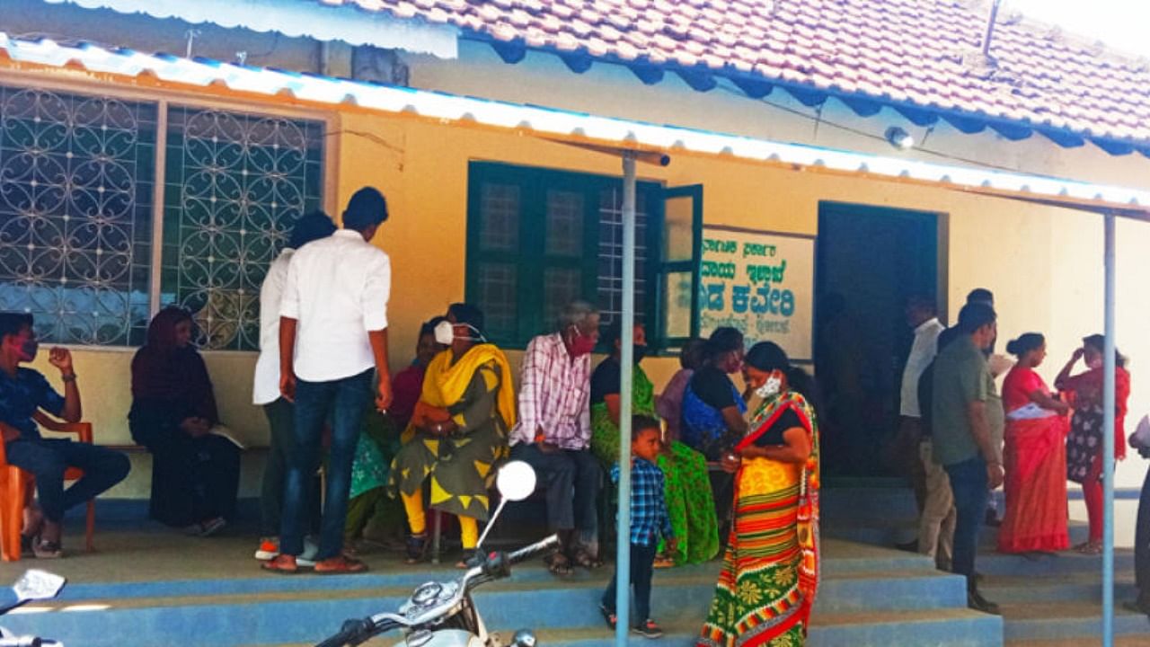 People wait in front of the Nadakatcheri office in Suntikoppa. Credit: Special arrangement.