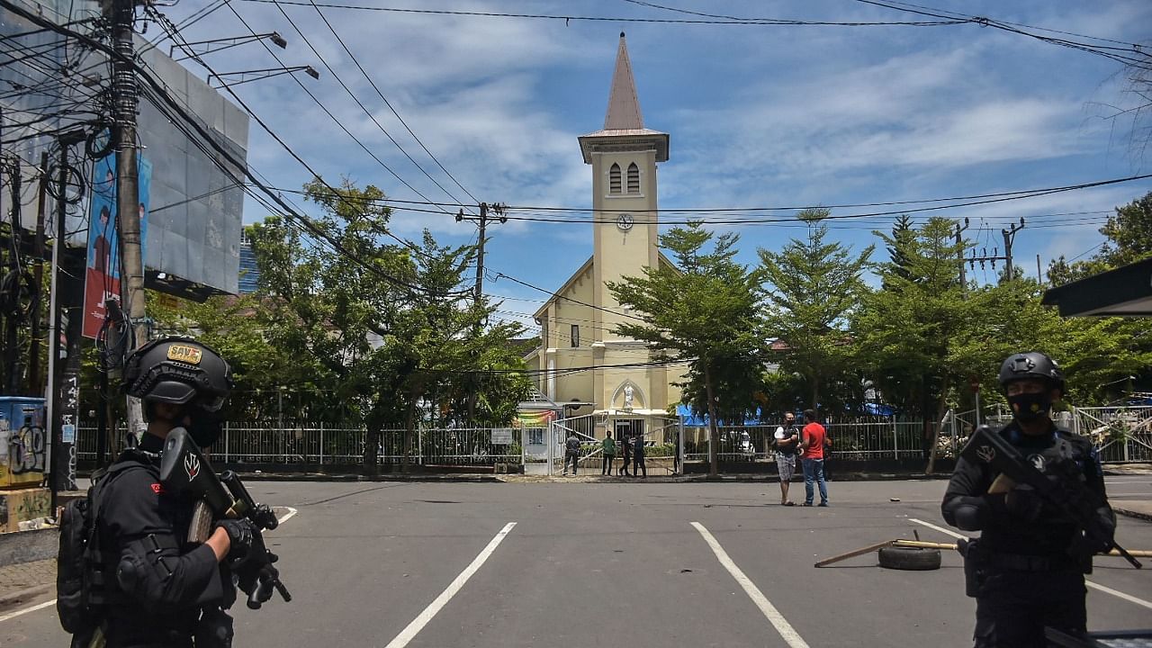 Indonesian police stand guard outside a church after an explosion in Makassar. Credit: AFP Photo