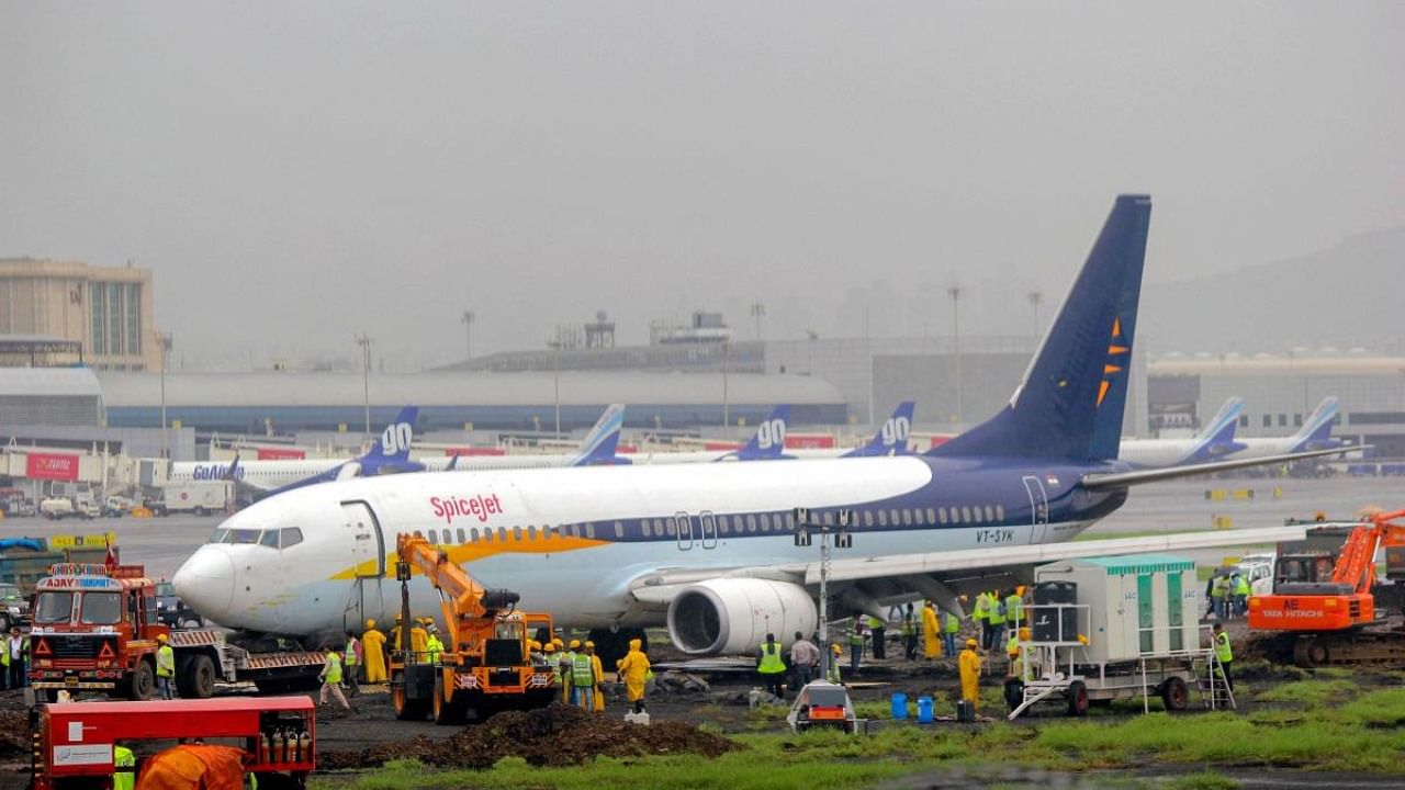 A team of engineers and technicians from Air India work to remove the SpiceJet aircraft. Credit: PTI Photo