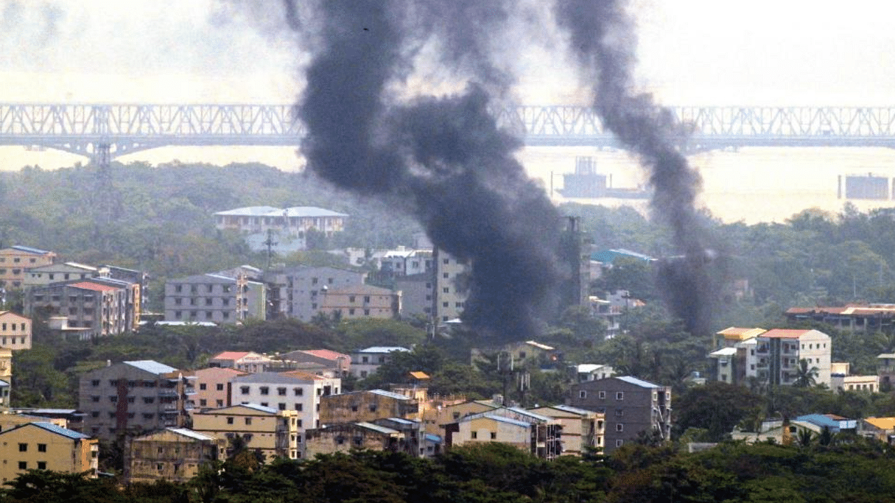 Smoke rises over Thaketa township in Yangon on March 27, 2021, as security forces continue their crackdown on protests against the military coup.  Credit: AFP Photo