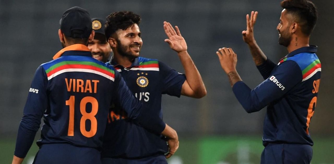 India's Shardul Thakur (C) celebrates with teammates after taking a wicket during the third and final ODI against England in Pune. Credit: AFP Photo