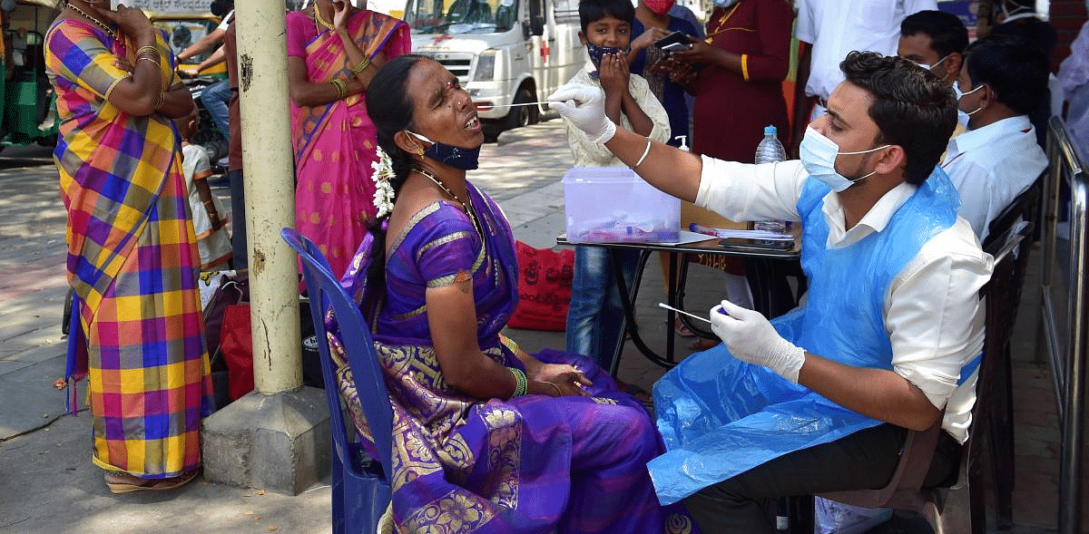  A health worker conducts Covid-19 testing of a passenger at KSRTC bus stand, amid a surge in coronavirus cases in Bengaluru. Credit: PTI photo. 