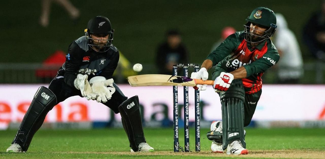 Bangladesh's Mahmudullah (R) plays a shot as New Zealand's wicketkeeper Devon Conway (L) reacts during the second Twenty20 cricket match between New Zealand and Bangladesh in Napier. Credit: AFP Photo