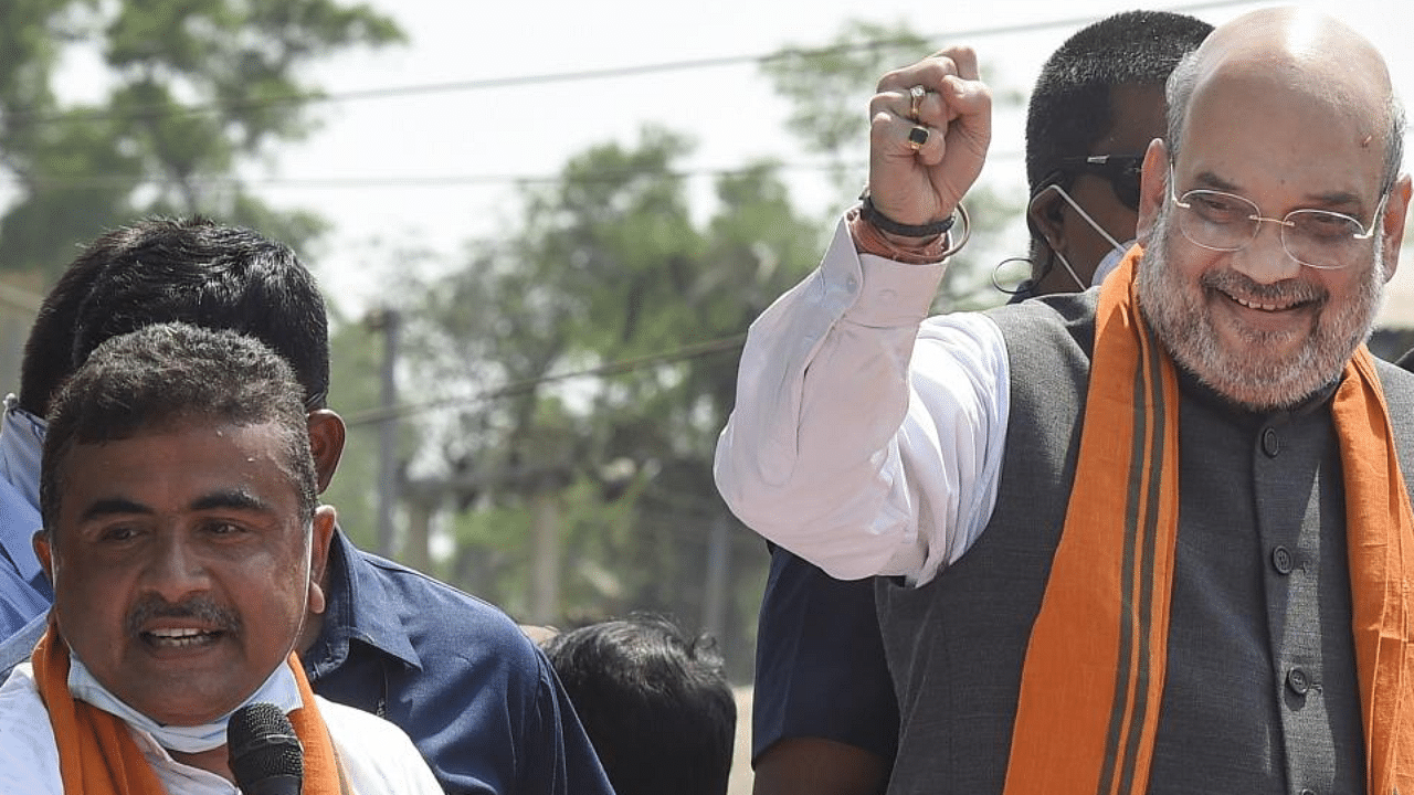 Union Home Minister Amit Shah during a road show in support of BJP candidate Suvendu Adhikari (L) from Nandigram Constituency for the Assembly elections, in Nandigram, Tuesday, March 30, 2021. Credit: PTI Photo