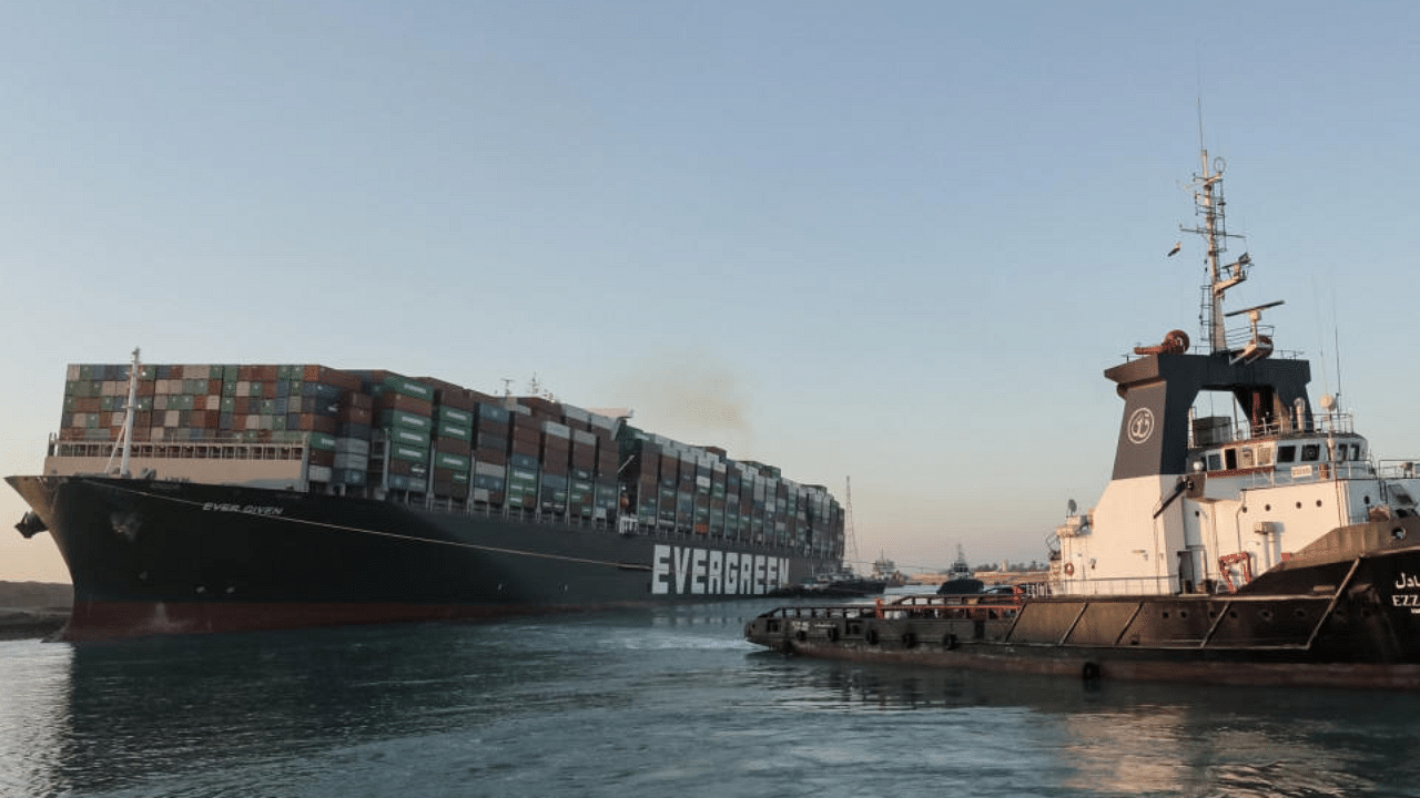 A handout picture released by the Suez Canal Authority on March 29, 2021 shows tugboats pulling the Panama-flagged MV 'Ever Given' (operated by Taiwan-based Evergreen Marine) container ship, a 400-metre- (1,300-foot-)long and 59-metre wide vessel, lodged sideways impeding traffic across Egypt's Suez Canal waterway.  Credit: AFP Photo