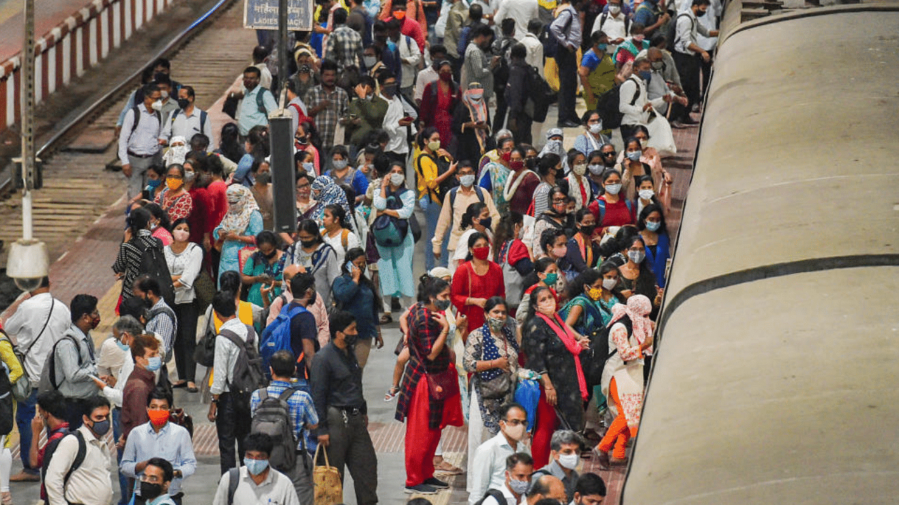 Commuters rush to board a suburban train at CSMT station prior to the night curfew, amid coronavirus pandemic, in Mumbai, Tuesday, March 30, 2021. Credit: PTI Photo