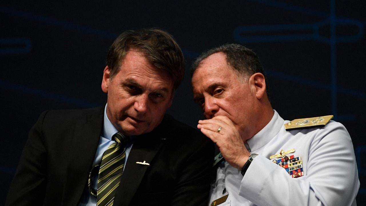 n this file photo taken on October 11, 2019, Brazilian President Jair Bolsonaro (L) speaks with Brazil's Navy Commander Ilques Barbosa Junior. Credit: AFP Photo