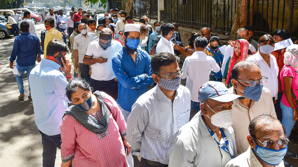 Staff members and others visiting a Sessions Court stand in a queue to register themselves for Covid-19 tests. Credit: PTI Photo