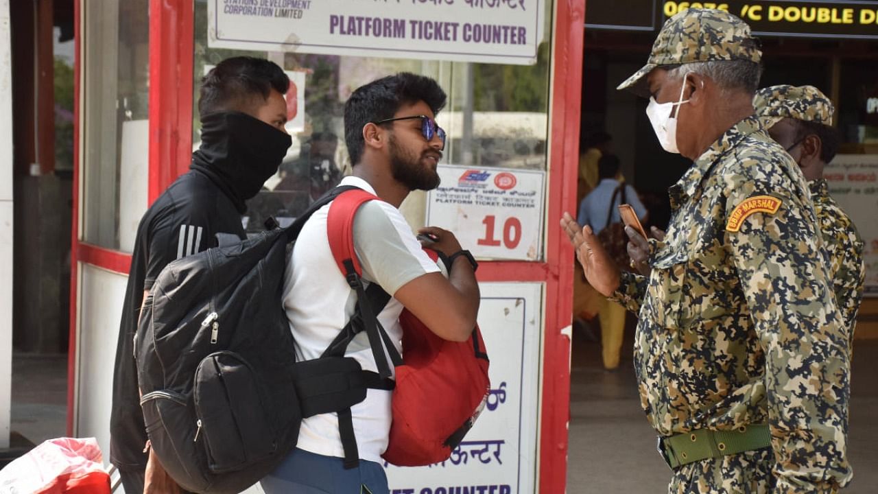 BBMP marshals fine people without masks at KSR railway station in Bengaluru on Tuesday. Credit: DH Photo/Janardhan B K.
