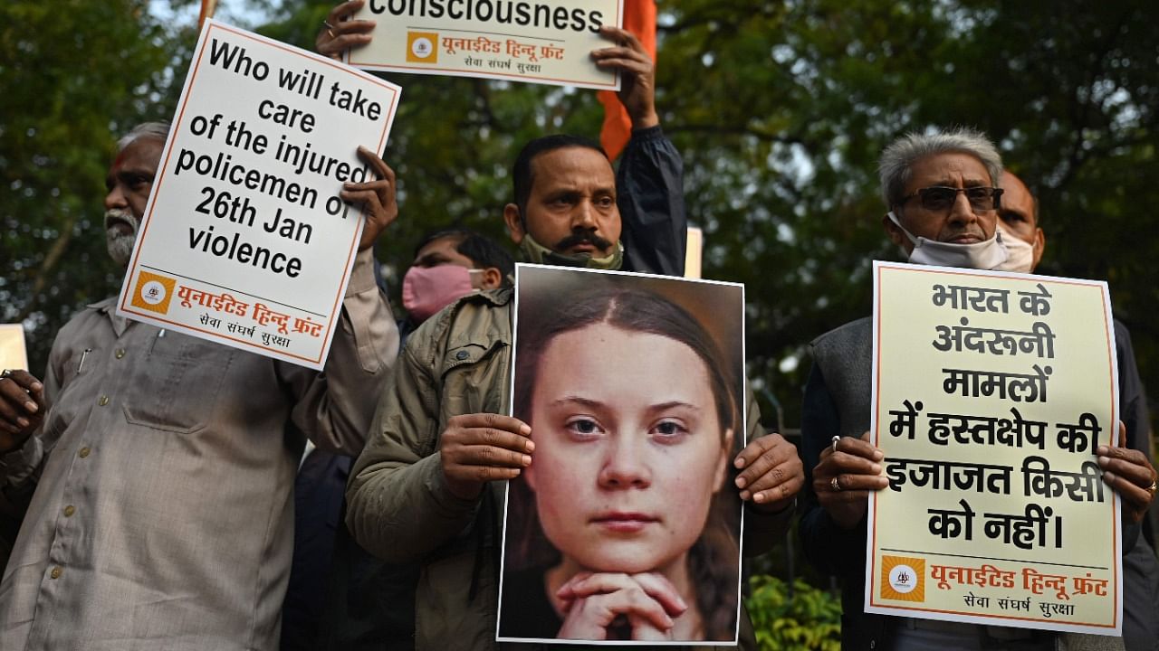 Activists of United Hindu Front (UHF) hold placards and a picture of Swedish climate activist Greta Thunberg during a demonstration in New Delhi. Credit: AFP File Photo.