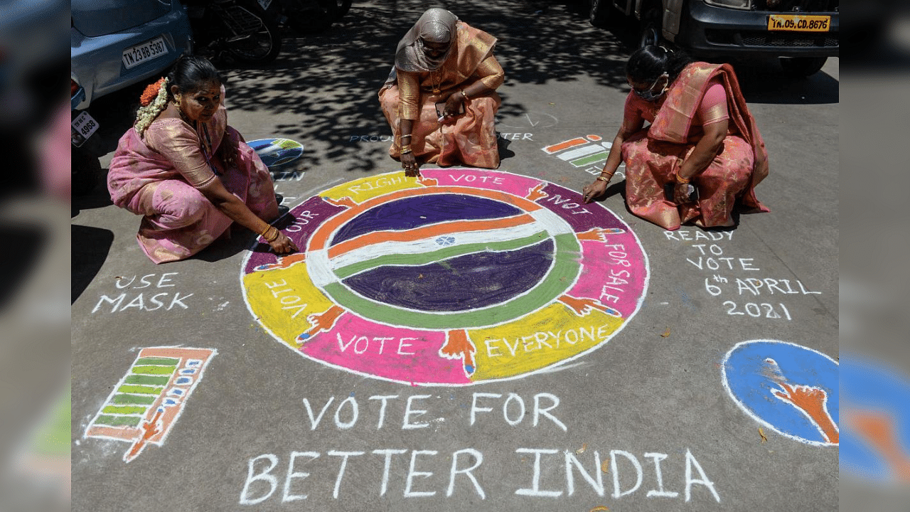 Electoral workers draw a rangoli during an election rally ahead of the Tamil Nadu legislative assembly elections, in Chennai on March 8, 2021. Credit: AFP Photo