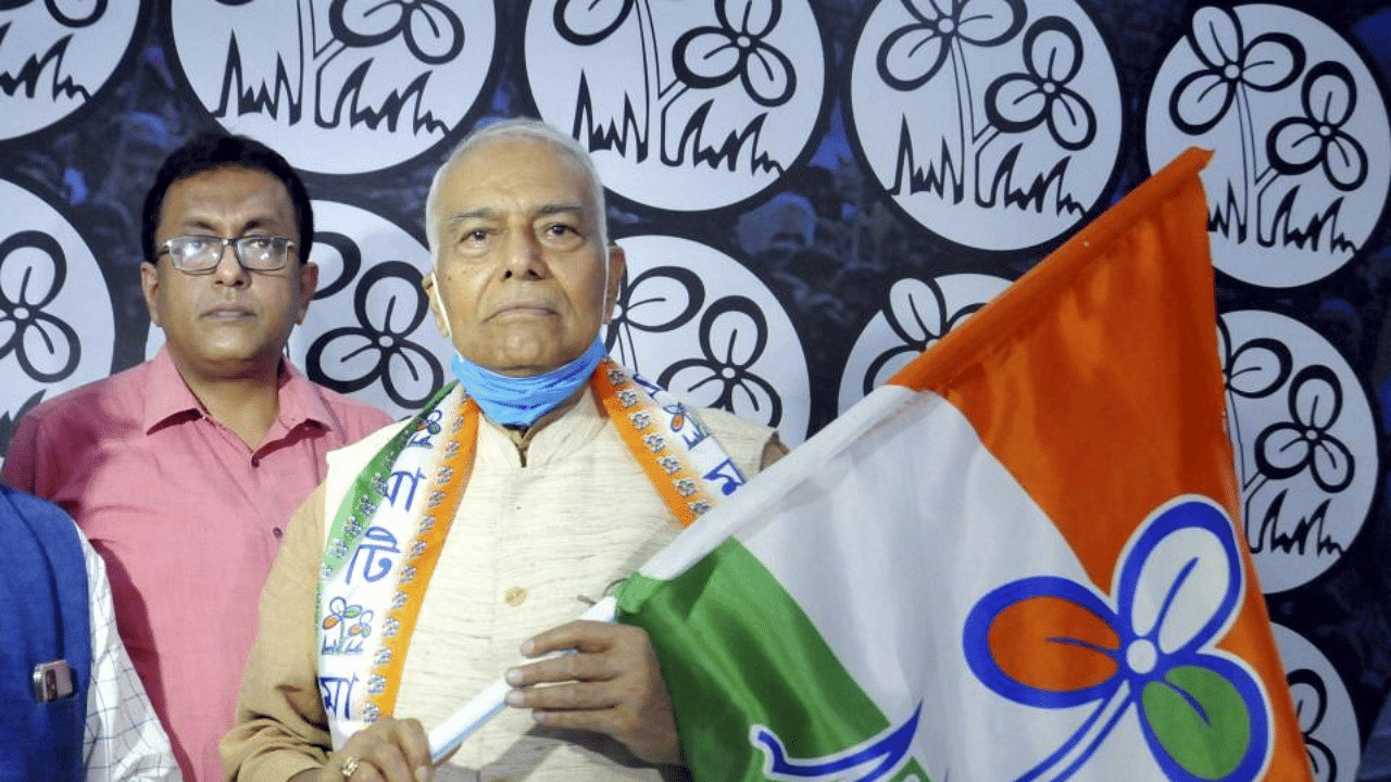 West Bengal Panchayat and Rural Development Minister Subrata Mukherjee (L) hands over the party flag to former BJP leader Yashwant Sinha (R). Credit: PTI Photo