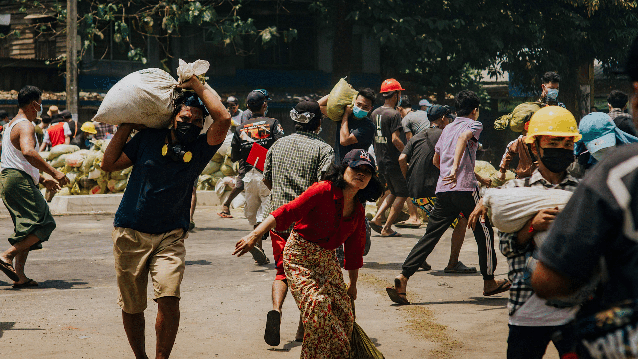 Protesters carrying sand bags to build road barricades during a demonstration against the military coup in Insein township in Yangon. Credit: AFP Photo