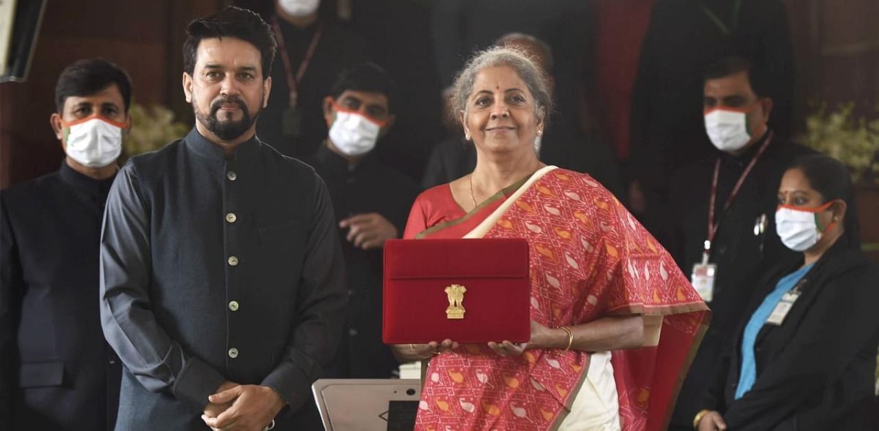 Finance Minister Nirmala Sitharaman holds a folder case containing the Union Budget 2021-22, during the Budget Session of the Parliament, at Parliament House in New Delhi, Monday, Feb. 1, 2021. MoS Finance Anurag Thakur is also seen. Credit: PTI Photo