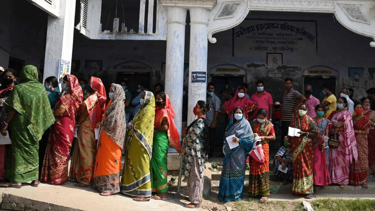 Voters stand in a line to cast their vote outside a polling station during Phase 2 of West Bengal's legislative election in Nandigram on April 1, 2021. Credit: AFP Photo