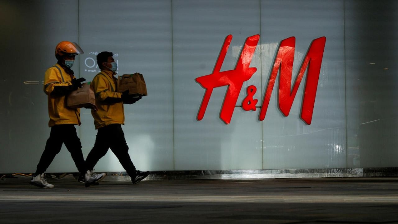 People walk past an H&M store in a shopping area in Beijing, China. Credit: Reuters.