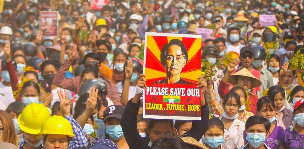 This photo taken and received from an anonymous source via Facebook on April 1, 2021 shows a protester holding up a poster featuring detained civilian leader Aung San Suu Kyi during a demonstration against the military coup in Monywa, Sagaing region. Credit: AFP photo.