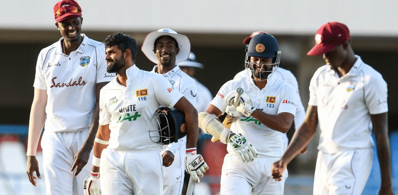 Lahiru Thirimanne (2L) and Dinesh Chandimal (2R) of Sri Lanka laugh with Jason Holder (L) and Hayden Walsh Jr. (C) of West Indies while walking off the field at the end of day 4 of the 2nd Test between West Indies and Sri Lanka at Vivian Richards Cricket Stadium in North Sound, Antigua and Barbuda. Credit: AFP photo.