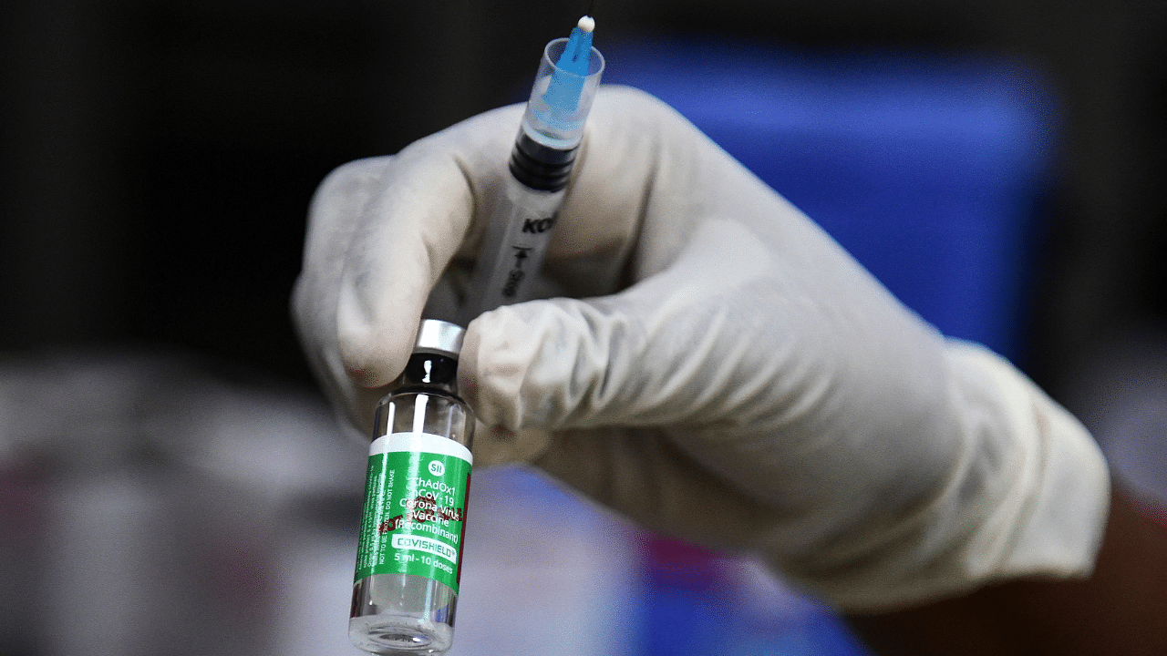 A medical worker holds a vial of the Covishield Covid-19 vaccine. Credit: AFP Photo.