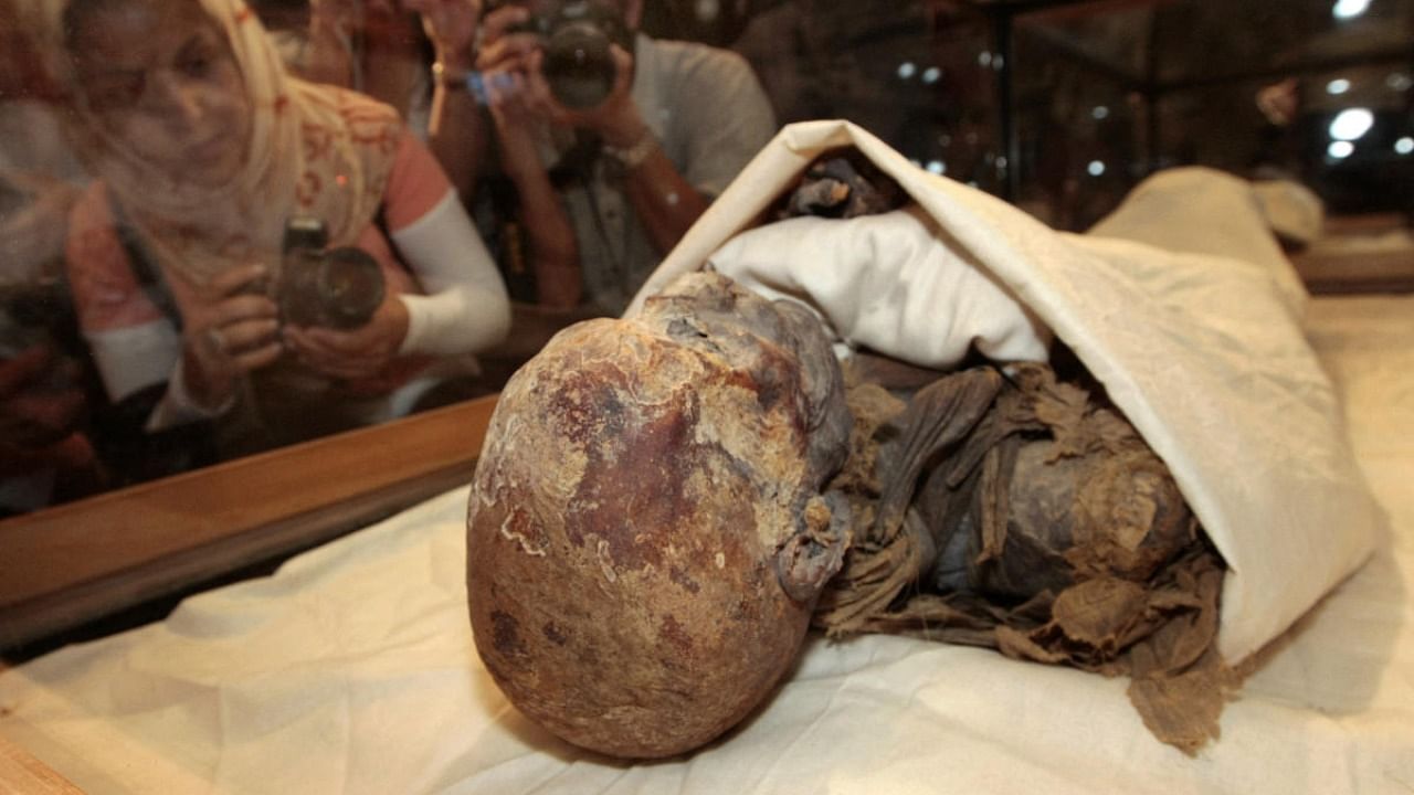 In this file photo taken on June 27, 2007, people take pictures of the mummified remains of Queen Hatshepsut, ancient Egypt's most famous female pharaoh, displayed in a glass case after being unveiled at the Cairo Museum. Credit: AFP.
