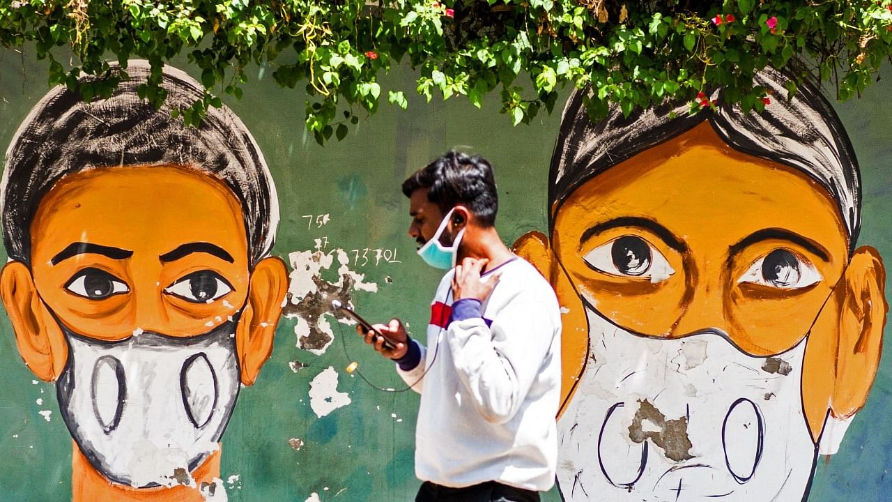 A man walks past a Covid-19 coronavirus awareness mural in New Delhi on April 2, 2021. Credit: AFP Photo