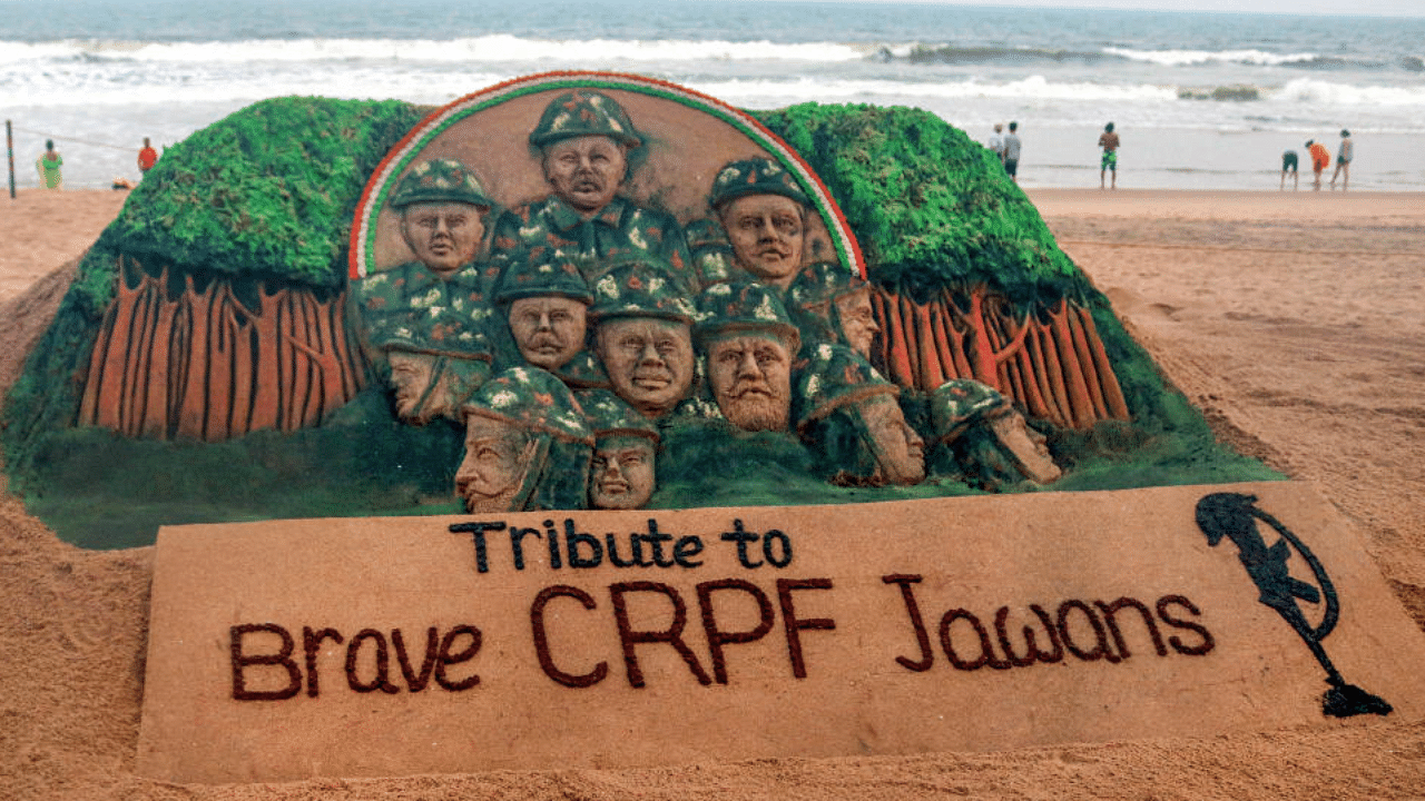 Sand artist Sudarsan Pattnaik creates a sand sculpture to tribute the CRPF jawans who lost their lives in Chhattisgarh Maoist attack, at Puri beach of Odisha, Sunday, April 4, 2021. Credit: PTI Photo