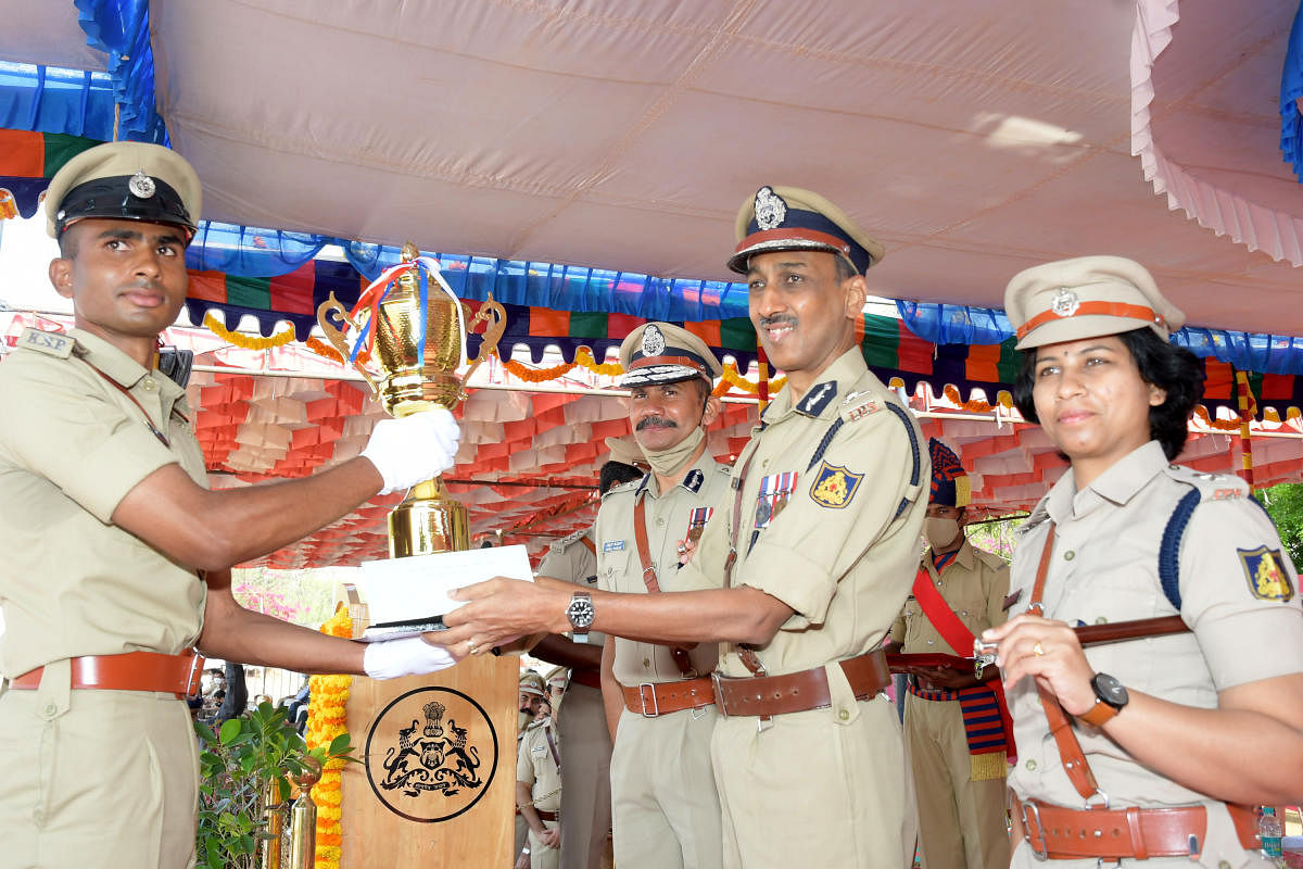Director General of Police, Training, Padam Kumar Garg gives away Chief Minister Trophy to probationary Police Sub-Inspector K R Chintan, during passing out parade at Parade grounds in Mysuru on Saturday. KPA Director Vipul Kumar and Deputy Director Suman Pennekar are seen. Credit: DH Photo