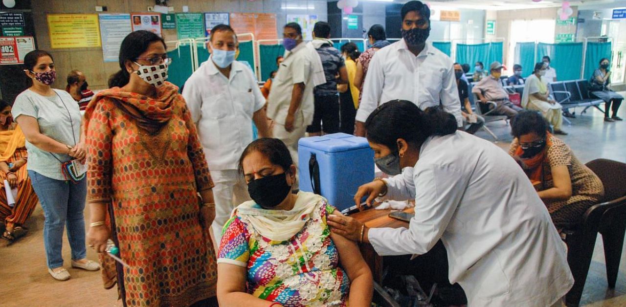 A health worker administers Covid-19 vaccine doses to people in Noida. Credit: PTI photo. 
