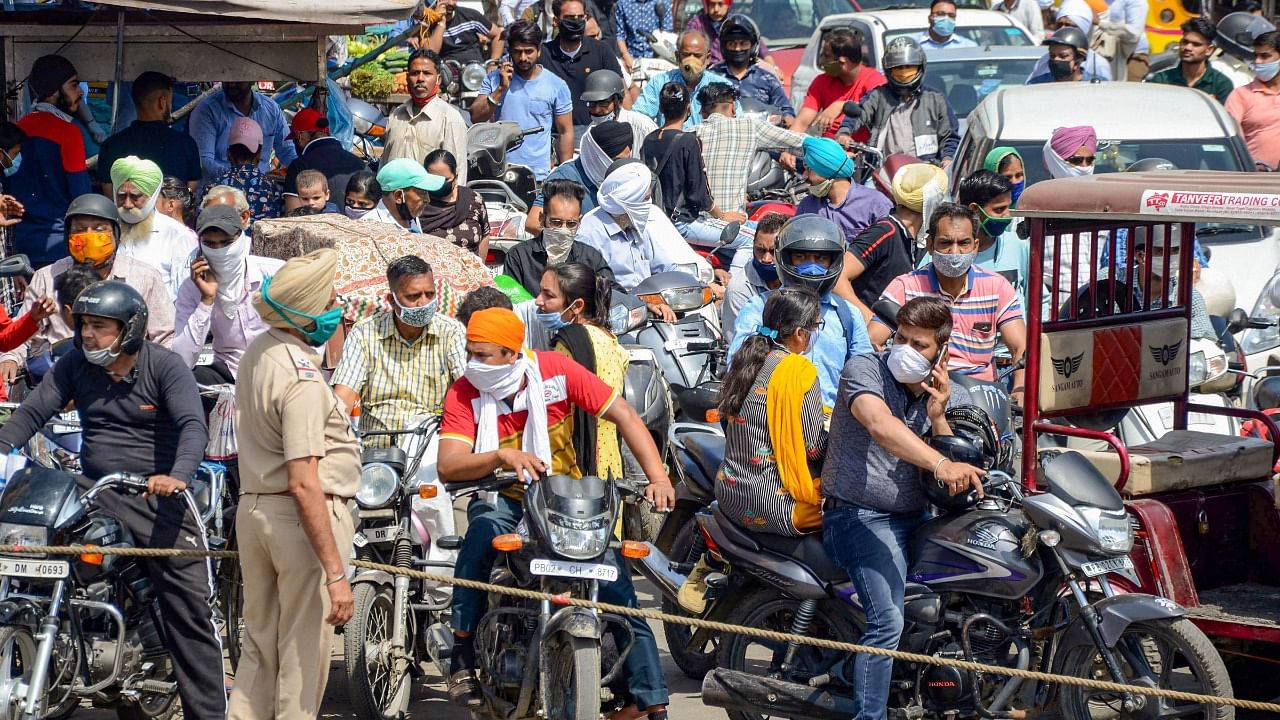 A police personnel tries to stop commuters during one-hour silence in the state to pay homage to the people who lost their lives due to Covid-19 in Punjab, in Amritsar, Saturday, March 27, 2021. Credit: PTI Photo
