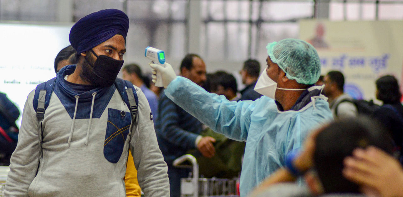 A medic official uses thermal screeing device on a passenger in the wake of deadly coronavirus, at an airport in Dibrugarh. Credit: PTI Photo