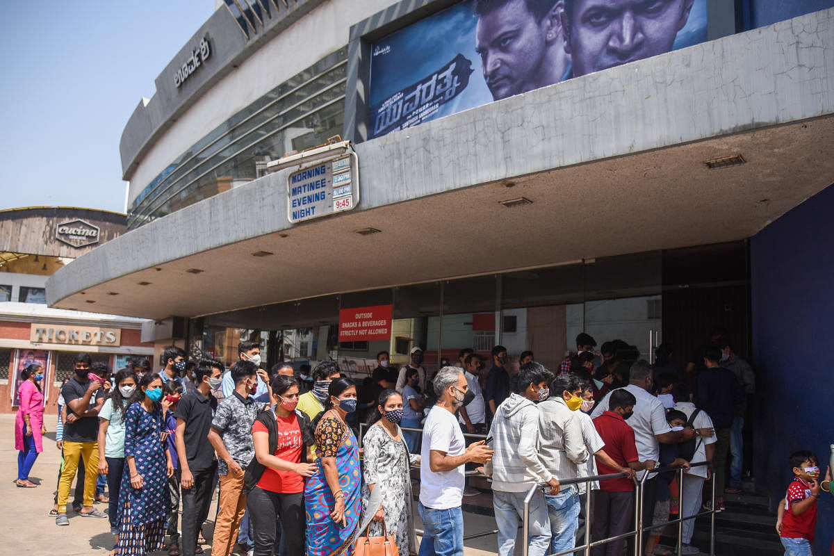 People queue up at a theatre to watch the Kannada film “Yuvarathnaa,” in Bengaluru on Sunday. DH Photo/S K Dinesh