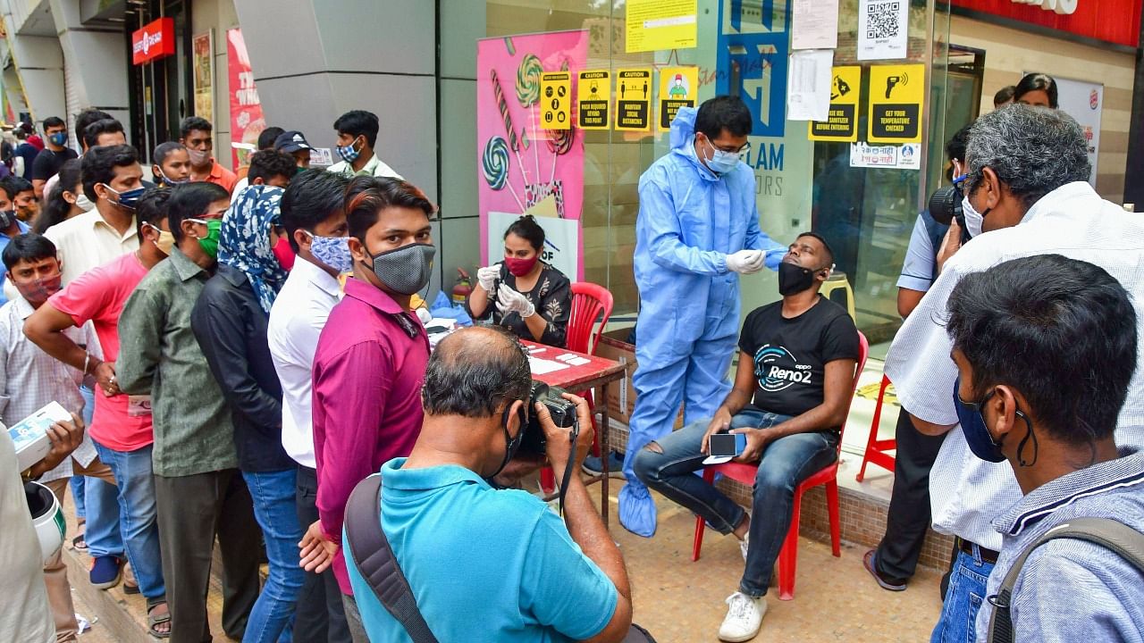 A health worker takes swab samples of visitors for Covid-19 tests, at a mall at Dadar in Mumbai, Tuesday, March 23, 2021. Credit: PTI Photo