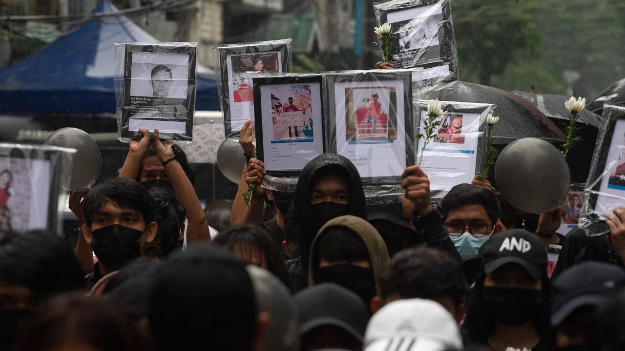Protestors in Myanmar holding photos of those that have died in the junta crackdown. Credit: AFP Photo